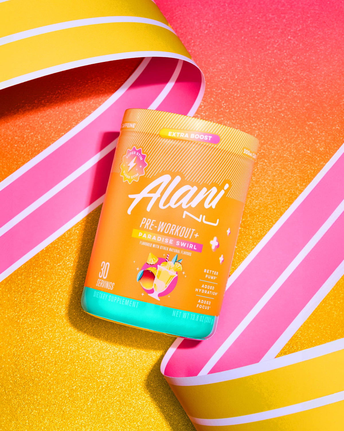 A container of Alani Nu Pre-Workout + - Paradise Swirl supplement in vibrant packaging with striped ribbons, positioned on a colorful background. The label highlights &quot;30 servings, dietary supplement,&quot; with a net weight of 7.05 oz (200 g). Available at The Vitamin Shoppe.